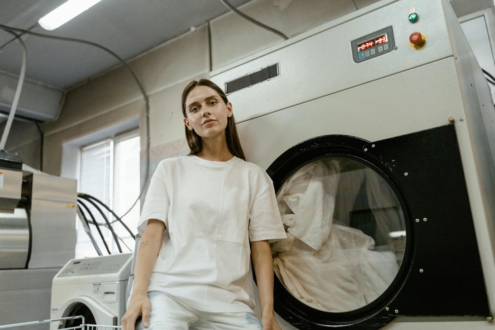 young woman sitting in a laundry facility